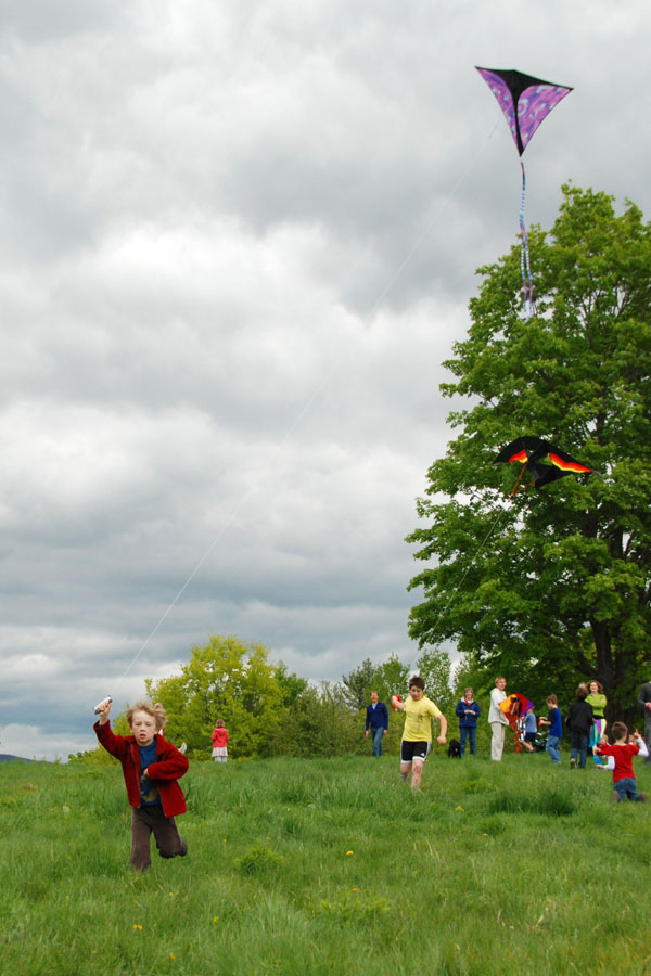 A child runs around the summit of Balch Hill on Kite Day, an annual event sponsored by Red Kite Candy. Photo by Lisa Densmore.