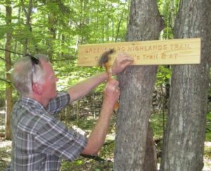 volunteer mounting a trail sign